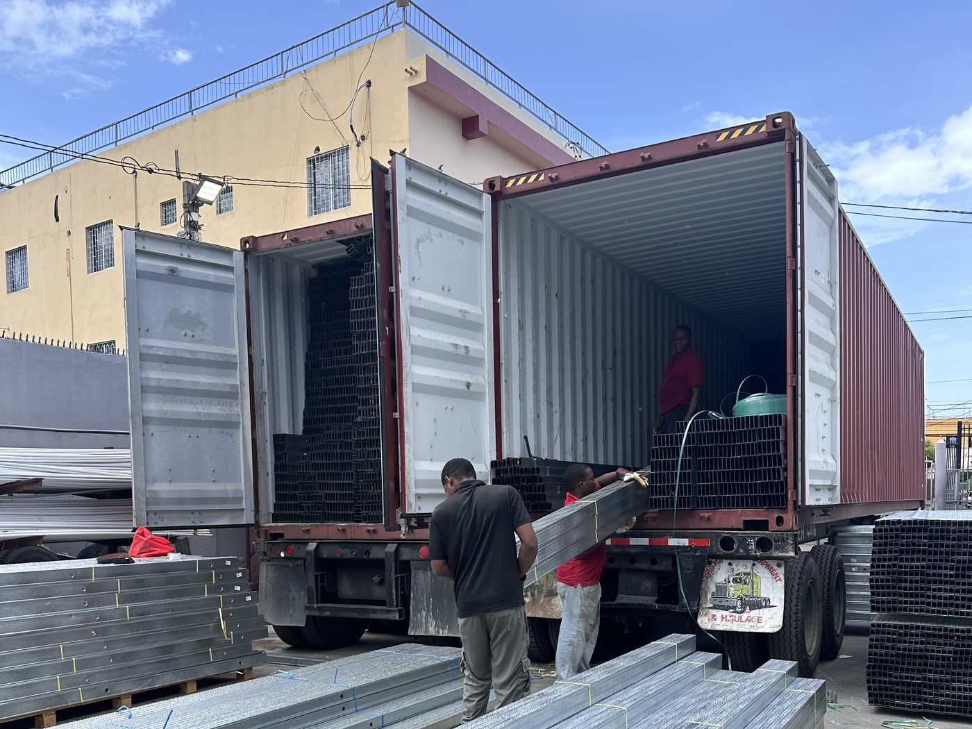 The LleWatson team unloading a container of steel studs in the yard
